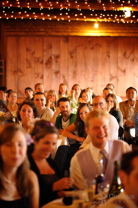 audience watching photo slideshow at wedding reception.