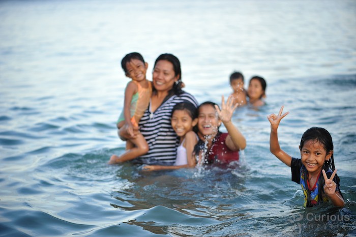 Balinese family at smiling for photo at Sanur Beach in Bali